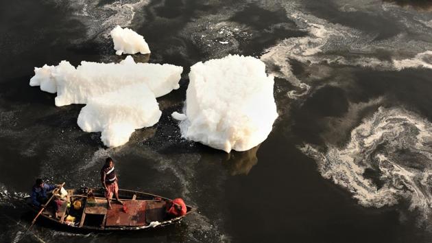 A boat rows through the foam filled Yamuna river near Kalindi Kunj, in Noida, Uttar Pradesh. (Virendra Singh Gosain / HT Photo)
