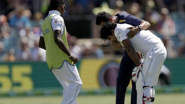 Sri Lanka's Kusal Perera, right, is helped by training staff as he tries to walk off the ground after he was struck on the head by a delivery from Australia's Jhye Richardson on day 3 of their cricket test match in Canberra, Sunday, Feb. 3, 2019(AP)