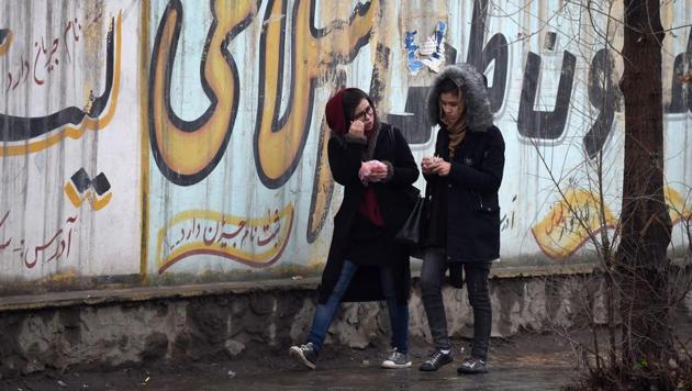 Afghan girls walk next to graffitis on a wall in Kabul on January 30. (AFP Photo) Afghan girls walk next to graffitis on a wall in Kabul on January 30. (AFP Photo)