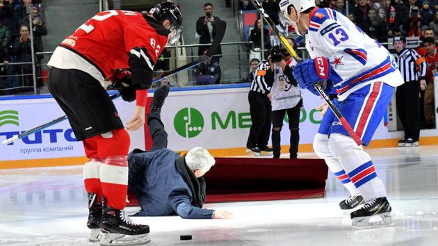 Portuguese soccer manager Jose Mourinho falls down, as ice hockey players Evgeny Medvedev and Pavel Datsyuk stand nearby(REUTERS)