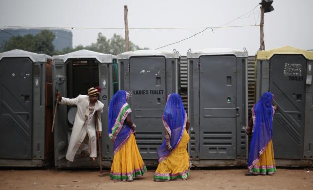 A groom comes out from a toilet as brides stand at the venue for a mass wedding ceremony, Ramlila Ground, New Delhi(REUTERS)