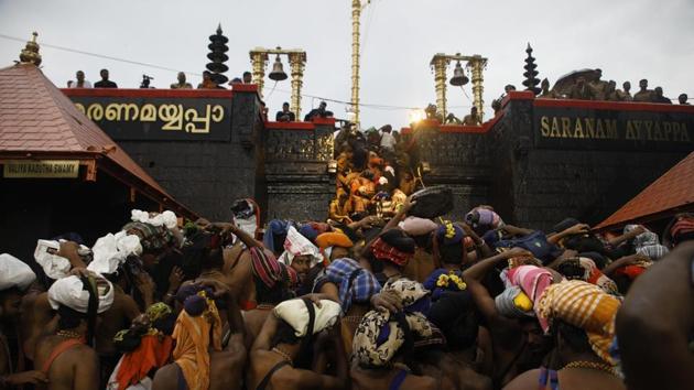 Devotees climb over the holy eighteen golden steps to worship diety of Hindu god Ayyapa at a temple premises in Sabarimala in the southern state of Kerala on November 16.(HT File Photo/Vivek Nair)