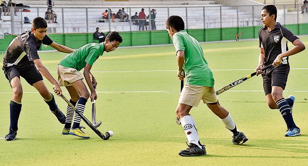 Pune Police Public School (green) in action against Loyola High School at Major Dhyanchand Hockey Poligras Stadium, Pimpri-Chinchwad on Tuesday.(HT PHOTO)