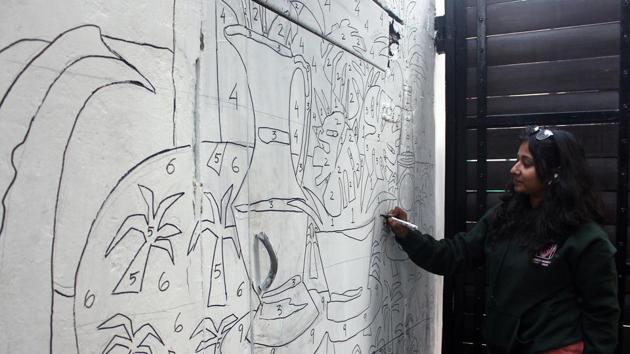 An artist works on a paint by numbers mural outside Studio Khirki which hosted the Irragulars Art Fair(SHivam Saxena-HT)