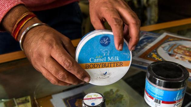 A shopkeeper displays body butter made from camel milk at a camel research farm in Bikaner. Far away in city supermarkets demand for chocolates, soaps and skin creams made from such milk is growing -- a boon for nomads like the Raikas and India’s fast disappearing camels. (Chandan Khanna / AFP)