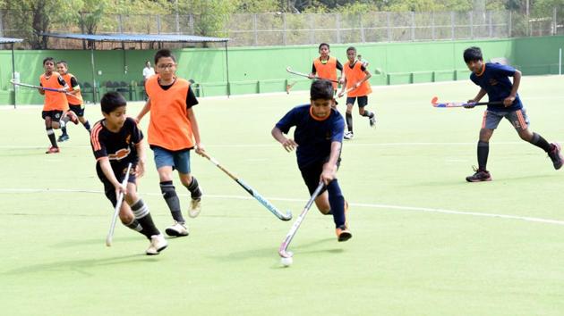 St Ursula High School (orange) in action against Genba Sopanrao Moze Prashala at Major Dhyanchand Hockey Poligras Stadium, Pimpri-Chinchwad on Wednesday. (HT PHOTO) 