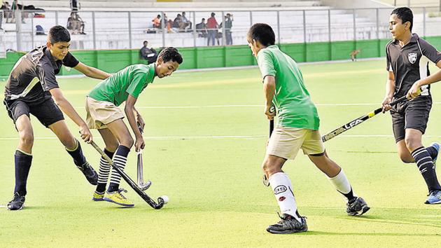 Pune Police Public School (green) in action against Loyola High School at Major Dhyanchand Hockey Poligras Stadium, Pimpri-Chinchwad on Tuesday. (HT PHOTO) 