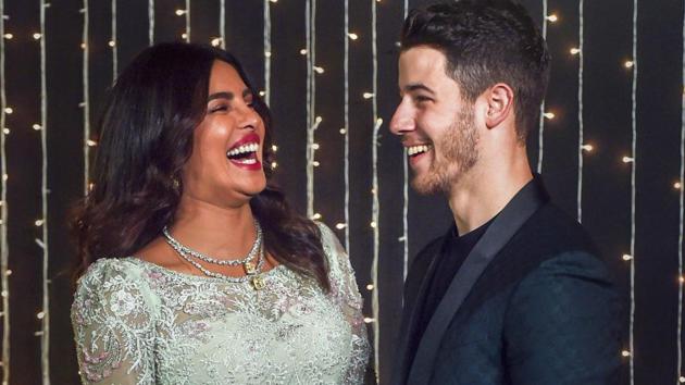 Priyanka Chopra with husband Nick Jonas pose for photos during their wedding reception, in Mumbai.(PTI)