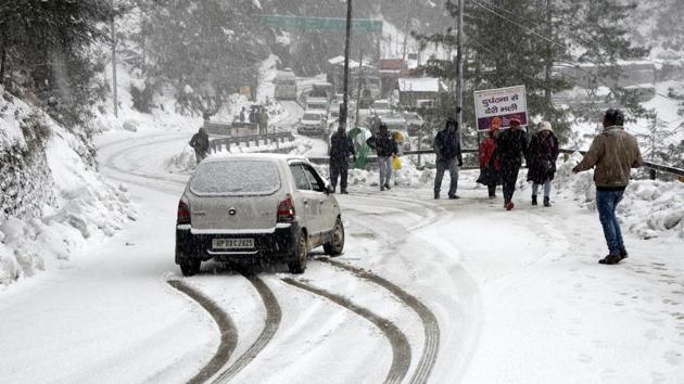 Vehicles moving slowly on the snow-covered Dhalli-Kufri highway during in Shimla, Himachal Pradesh.(Deepak Sansta / HT Photo)
