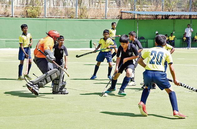 Loyola High School (black) in action against Lokseva Prathisthan in the under-13 semi-final of the Father Schoch Memorial Hockey championship at Major Dhyan Chand Hockey Poligras Stadium, Pimpri-Chinchwad, on Thursday.(HT PHOTO)