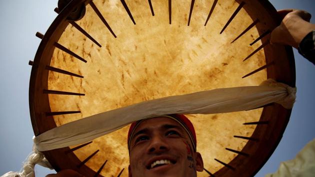 A man dressed in traditional attire holds a drum above his head as he sings and dances during the Sonam Lhosar in Kathmandu, Nepal. (Navesh Chitrakar / REUTERS)