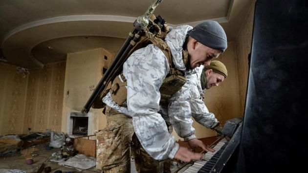 Members of the Ukrainian Armed Forces play the piano in а destroyed house near their position on the front line in Donetsk Region, Ukraine. (Oleksandr Klymenko / REUTERS)