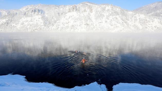 Members of the Dolphin winter swimming club swim in the icy waters of the Yenisei River during their weekly bathing session, with the air temperature at about minus 28 degrees Celsius in the Siberian town of Divnogorsk, Russia. (Ilya Naymushin / REUTERS)