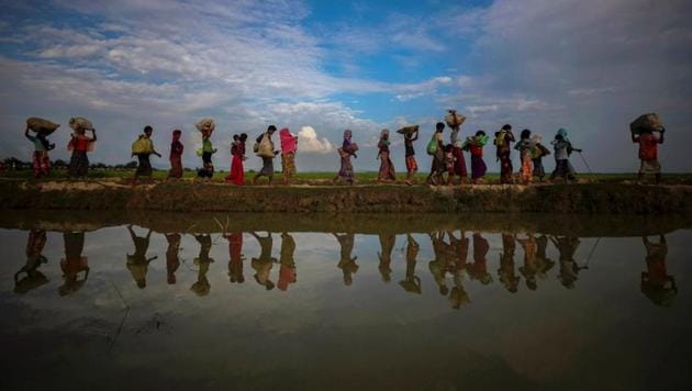 Rohingya refugees are reflected in rain water along an embankment next to paddy fields after fleeing from Myanmar into Palang Khali, near Cox's Bazar, Bangladesh November 2, 2017. (REUTERS) Rohingya refugees are reflected in rain water along an embankment next to paddy fields after fleeing from Myanmar into Palang Khali, near Cox's Bazar, Bangladesh November 2, 2017. (REUTERS)
