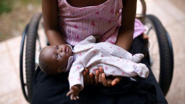 A five-year-old girl poses with her doll as she sits in her wheelchair in the courtyard of the Aberdeen Women’s Center, one year after a sexual assault that her family says left her paralysed, in Freetown, Sierra Leone. (Cooper Inveen / REUTERS)