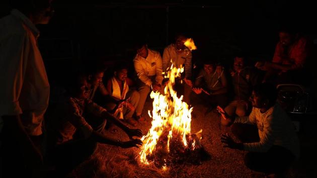People sit around camp fire on a winter evening at Gujarwadi in Pune, India, on Saturday. (Rahul Raut/HT PHOTO) People sit around camp fire on a winter evening at Gujarwadi in Pune, India, on Saturday. (Rahul Raut/HT PHOTO)
