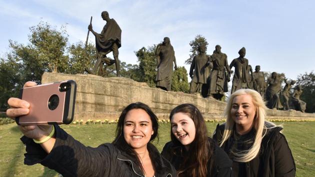 Tourists take selfies during their visit to the Dandi March Statue, near Mother Teresa Crescent Road, in New Delhi. While Raj Ghat and Gandhi Smriti are two of the most famous places on the city’s tourist trail, there are little-known places such as Valmiki Basti and Kasturba Kutir near Kingsway Camp in north Delhi where Gandhi spent a lot of time. (Sanjeev Verma / HT Photo)