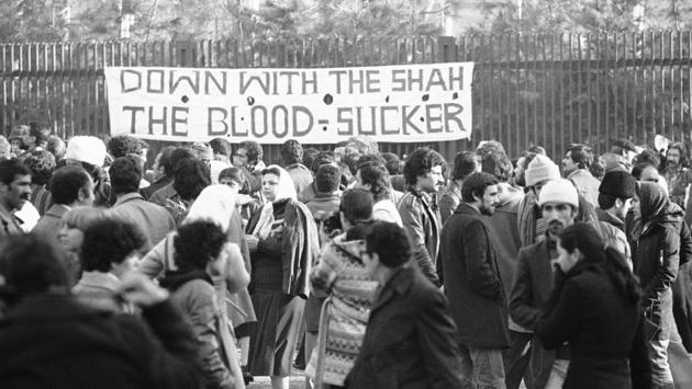 A banner denouncing the shah at the entrance of Tehran University in January 1979. In December, rioters burned down the headquarters of the US Grumman Aircraft Corp in Isfahan. An attempt to storm the US Embassy in Tehran resulted in US Marines firing tear gas. On December 29, the shah asked Shapour Bakhtiar of the opposition National Front to form a civilian government. (Bernhard Frye / AP File) A banner denouncing the shah at the entrance of Tehran University in January 1979. In December, rioters burned down the headquarters of the US Grumman Aircraft Corp in Isfahan. An attempt to storm the US Embassy in Tehran resulted in US Marines firing tear gas. On December 29, the shah asked Shapour Bakhtiar of the opposition National Front to form a civilian government. (Bernhard Frye / AP File)
