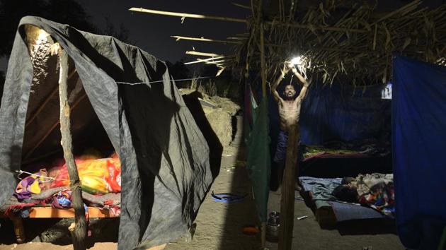 Sawanji Chimma Gavit prepares his family’s sleeping arrangements in the front yard of their home under tarpaulin sheet tents. More than 1,000 earthquakes of mild-to-medium magnitude have rocked Dahanu and Talasari since November 3 last year, according to data from the National Centre for Seismology (NCS). (Anshuman Poyrekar / HT Photo)