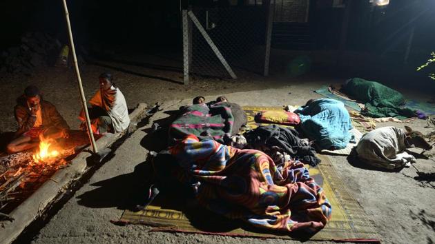 Families are cooking and feeding in the open, sleeping on the kutcha streets of the village, and reassuring each other in the middle of the night if they feel a tremor. Santosh Bhoye (L), a resident of Dhundalwadi, said, “My wife, two children, and four neighbouring families all sleep in a tent in the night. Sometimes we sleep on the road, but it is very cold in the night.” (Anshuman Poyrekar / HT Photo)