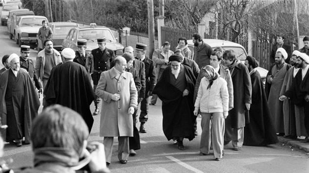 Future Iranian President Hassan Rohani (background 2nd-R, with turban and glasses) among companions of Ayatollah Ruhollah Khomeini walking out of his villa in France. On January 13, the shah appointed a regency council to represent the crown during his absence, while the Ayatollah announced the formation of a revolutionary council to prepare for an “Islamic republic” from Paris. (Marcel Binh / AFP File) Future Iranian President Hassan Rohani (background 2nd-R, with turban and glasses) among companions of Ayatollah Ruhollah Khomeini walking out of his villa in France. On January 13, the shah appointed a regency council to represent the crown during his absence, while the Ayatollah announced the formation of a revolutionary council to prepare for an “Islamic republic” from Paris. (Marcel Binh / AFP File)
