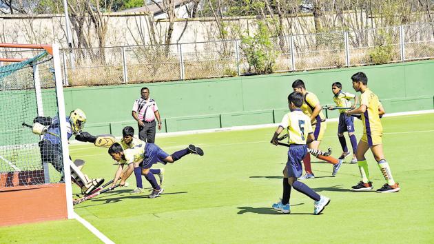 Lokseva Prathisthan (in yellow and blue) in action against St Joseph High School in the under-13 final of the Father Schoch Memorial hockey tournament at Major Dhyanchand hockey polygras stadium in Pimpri on Saturday.(HT PHOTO)