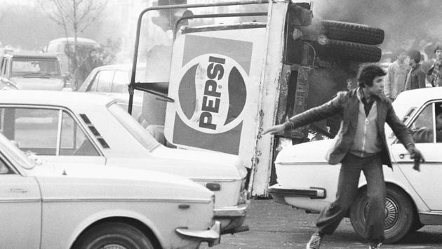 An overturned truck with a Pepsi logo burns during riots in Tehran. In early November, the cabinet resigned and was replaced by a military government headed by Gen. Gholam-Reza Azhari. Newspaper editors were arrested and censorship prompted a two-month newspaper strike. The shah pledged that “past mistakes of unlawfulness, cruelty and corruption will not be repeated.” (AP File) An overturned truck with a Pepsi logo burns during riots in Tehran. In early November, the cabinet resigned and was replaced by a military government headed by Gen. Gholam-Reza Azhari. Newspaper editors were arrested and censorship prompted a two-month newspaper strike. The shah pledged that “past mistakes of unlawfulness, cruelty and corruption will not be repeated.” (AP File)