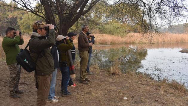 A group of bird watchers at Gurugram-Farrukhnagar road near Sultanpur Bird sanctuary, in Gurugram, on Sunday, February 3, 2019.(Yogendra Kumar/HT Photo)