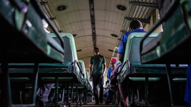A man searches for a vacant seat on-board the train. On the Bulawayo commuter train, some windows on older carriages are even still marked “RR” for “Rhodesian Railways” -- Zimbabwe’s name before independence in 1980. (Zinyange Auntony / AFP)