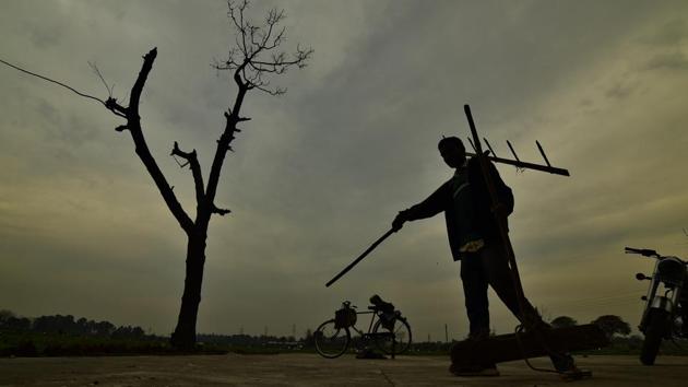 A farmer carrying his plow on his shoulder after ending up with the day on cloudy evening at his fields in a village near in Ludhiana. Image for representation.(Gurpreet Singh/HT File Photo)