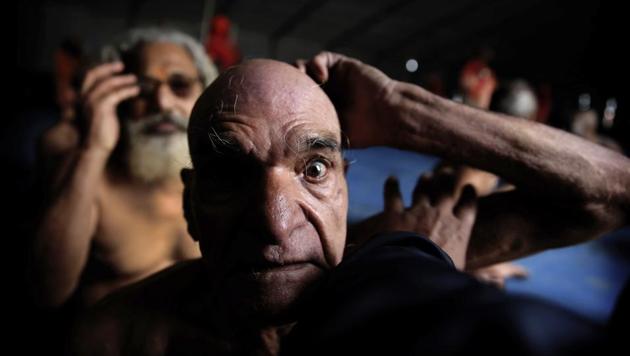 Hindu men get their hair cut in a ritual before becoming Naga Sadhus at Sangam, the confluence of three holy rivers during the Kumbh Mela. At every Kumbh, including this year’s, thousands of devotees are initiated into the reclusive sect of the Naga Sadhus — naked, ash-smeared cannabis-smoking Hindu ascetics and onetime-armed defenders of the faith who for centuries have lived in jungles and caves. (Rajesh Kumar Singh / AP)