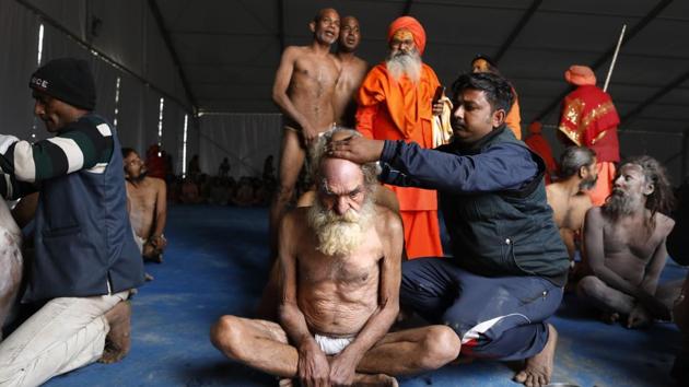 Performed by senior priests, the elaborate process of initiation comprises five rituals, starting with the shaving of heads and beards, ritual offering of saffron robes, wearing prayer beads, applying ash on the body and giving up their last piece of clothing. (Rajesh Kumar Singh / AP)