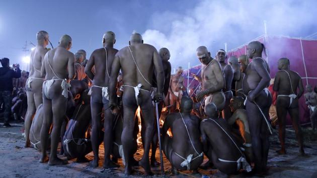 Men warm themselves around a bonfire after taking a dip during a process for becoming Naga Sadhus. “They will consider themselves dead, and only their soul will live on. They will pronounce themselves dead even while living,” said Santosh Mishra, a 50-year-old priest of the Juna Akhara monastic order. (Rajesh Kumar Singh / AP)
