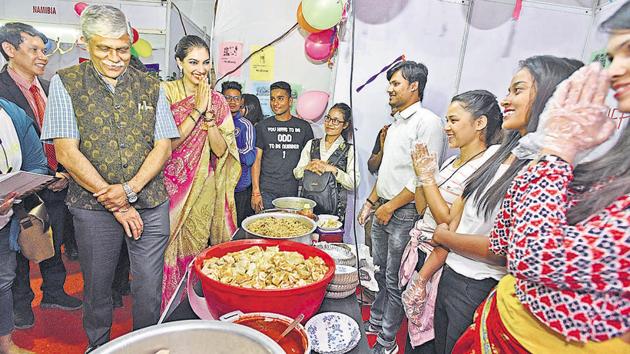 (Extreme left) Nitin Karmalkar, vice-chancellor, Savitribai Phule Pune University (SPPU), and (second from left) Yukta Mookhey Miss World 1999, visit food stalls during the International food festival at SPPU on Tuesday. (Pratham Gokhale/HT Photo) 