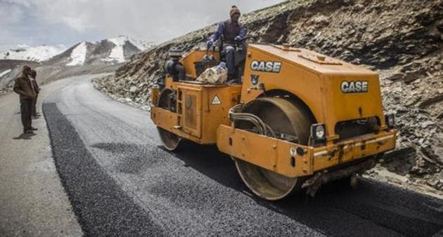 A Border Roads Organisation (BRO) worker drives a steamroller while repairing a road surface with tarmac on a section of the Leh Manali highway in Ladakh region.(Bloomberg)