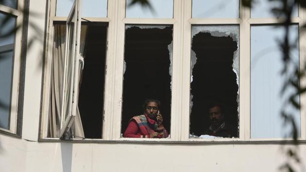 A woman is seen talking over the phone through the broken window after a massive fire broke out at Hotel Arpit Palace, in Karol Bagh in New Delhi, on Tuesday, February 12, 2019.(Biplov Bhuyan/HT Photo)