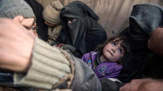 Women and children displaced from Deir Ezzor sit in the back of a truck. Their grimy faces are the only ones visible in the sea of black veils worn by their mothers, packed in the back of a dozen pickup trucks spiriting them away from the Islamic State group’s last holdout in eastern Syria. (Fadel Senna / AFP) Women and children displaced from Deir Ezzor sit in the back of a truck. Their grimy faces are the only ones visible in the sea of black veils worn by their mothers, packed in the back of a dozen pickup trucks spiriting them away from the Islamic State group’s last holdout in eastern Syria. (Fadel Senna / AFP)