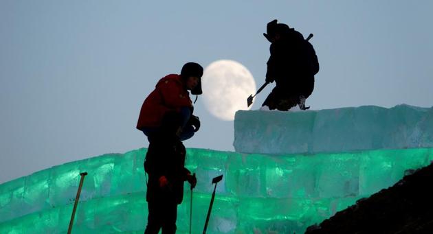 The moon shines as workers prepare an ice sculpture ahead of the Harbin International Ice and Snow Sculpture Festival in China. (REUTERS/Representative image)