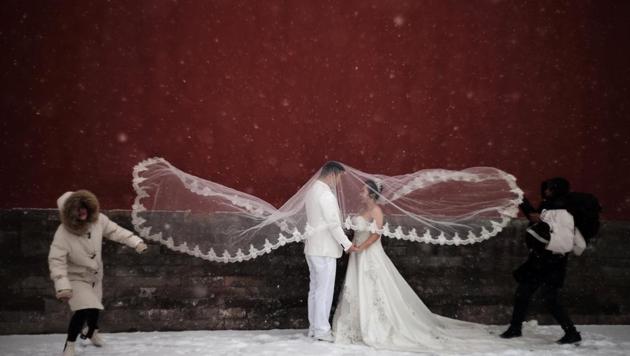 A couple poses for a wedding photo shoot amid snowfall at the Imperial Ancestral Temple in Beijing, China. (REUTERS)