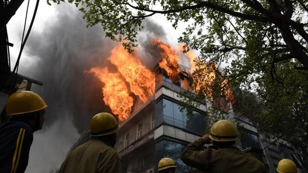 Fumes of smoke seen as firefighters try to douse the fire that broke out early morning at a card manufacturing factory, at Naraina Industrial area, in New Delhi. According to the fire department, no casualty has been reported yet. (Sanchit Khanna / HT Photo)