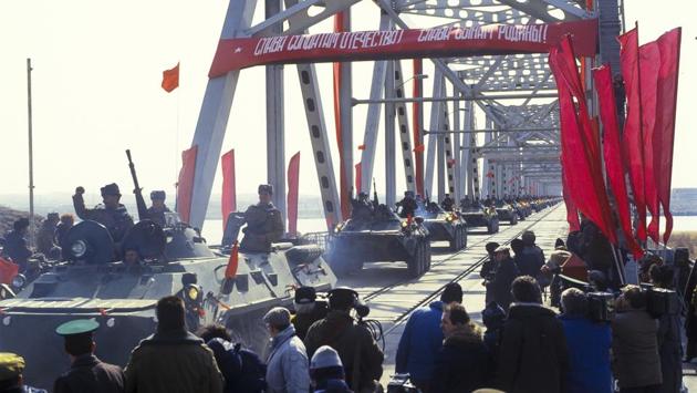 Soviet Army soldiers wave as they cross a bridge on the border between Afghanistan and then Soviet Uzbekistan. Noor described the Soviet pullout as a source of pride for Afghans. “The withdrawal of the Soviet Union was a historic day,” he said. “A poor nation with lots of problems, we defeated a superpower.” (Leonid Yakutin / Defense Ministry Press Service via AP)