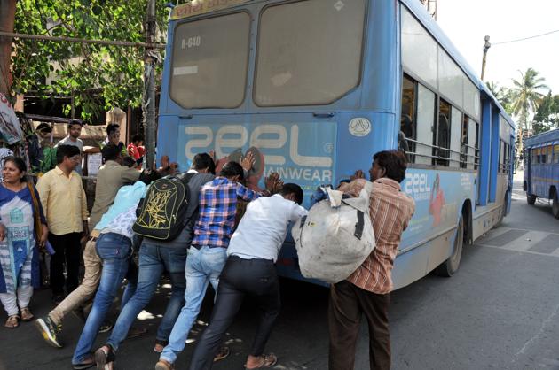 Passengers push a PMPML bus that brokedown at Alka Talkies chowk.(HT/PHOTO)