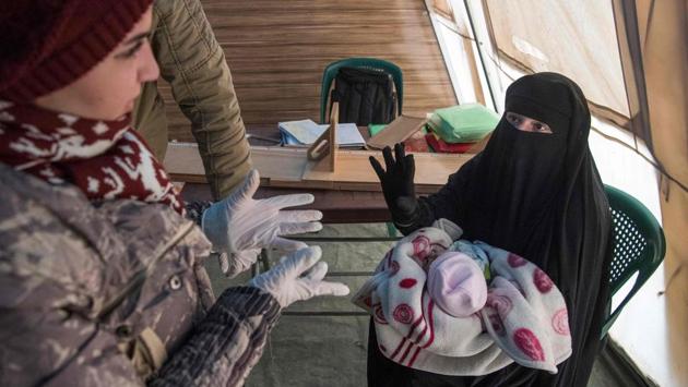 A Syrian woman holding a child talks to a medic at a makeshift clinic at the Internally Displaced Persons (IDP) camp of al-Hol in al-Hasakeh governorate. In the Al-Hol reception centre, women and children - most of them under five - sit on piles of blankets, waiting for a tent to become available. (Fadel Senna / AFP) A Syrian woman holding a child talks to a medic at a makeshift clinic at the Internally Displaced Persons (IDP) camp of al-Hol in al-Hasakeh governorate. In the Al-Hol reception centre, women and children - most of them under five - sit on piles of blankets, waiting for a tent to become available. (Fadel Senna / AFP)
