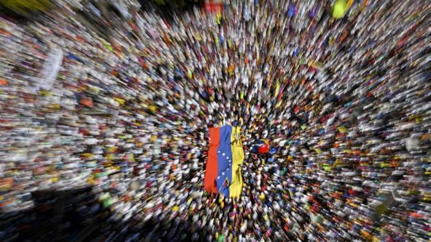 Supporters of Venezuelan opposition leader and self declared acting president Juan Guaido take part in rally to press the military to let in US humanitarian aid, in eastern Caracas. The war between the government and opposition is centred on whether humanitarian aid will be allowed into the economically crippled country, which suffers shortages of food, medicine and other basics. (Yuri CORTEZ / AFP)