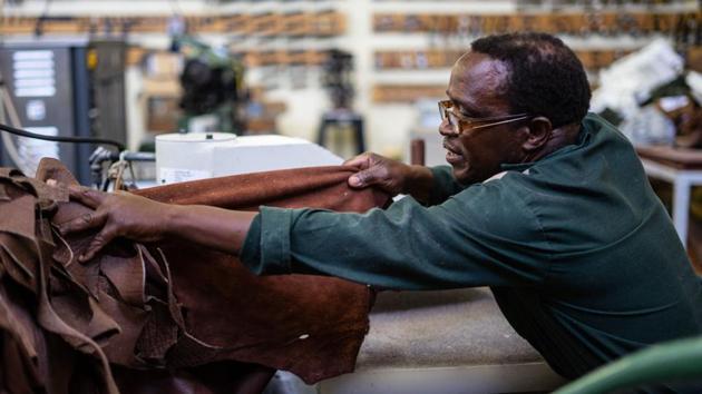 Leather cutter Misheck Sibanda selects leather that will be used to make shoes. He uses his sturdy cutting machine to press shapes out of locally produced leather skins at the start of a process that turns out boots selling for between $140 and $500 a pair. “We sell internationally -- to the first world, even though we are a third-world country. That alone makes me smile,” Sibanda said, deftly handling the soft leather skins. (Zinyange Auntony / AFP)