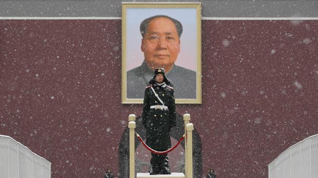 Chinese paramilitary policemen stand guard under the portrait of former leader Mao Zedong outside the Tiananmen Gate as snow falls in Beijing. (Andy Wong / AP)