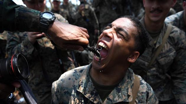 A soldier seen eating a scorpion during a jungle survival training in the joint 'Cobra Gold' military exercise in Chantaburi province. The annual joint war drill is the largest US-led military exercises in Asia involving gruelling drills in the Thai jungle, war games, humanitarian assistance and disaster relief exercise. (Lillian SUWANRUMPHA / AFP)