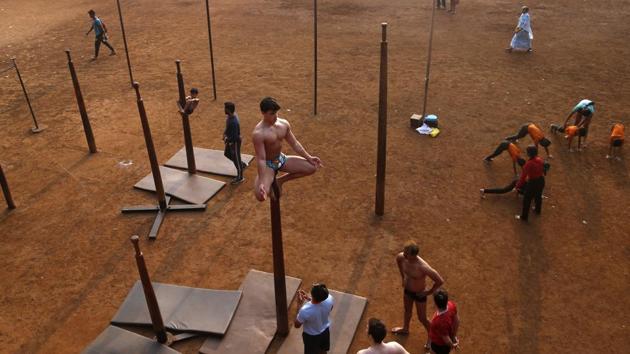 Vikram Nadkarni, of Newcastle, England, performs a Mallakhamb pose on a pole at Shivaji Park. In the evening, the historic Shivaji Park comes alive with mallakhamb players swirling around poles and on ropes, falling, only to get up and make another attempt. International players have started arriving to train. (Rafiq Maqbool / AP Photo)