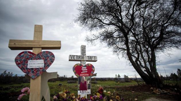 A cross for Victoria Taft, right, stands at a memorial for Camp Fire victims in Paradise. (Noah Berger / AP Photo)