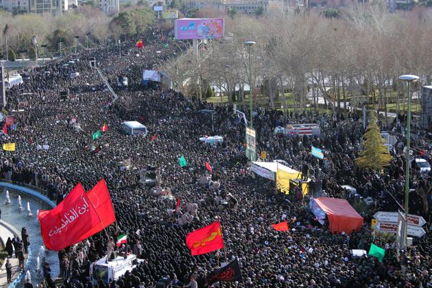 Iranian people along with members of Iran's elite Revolutionary Guards gather around the coffins of Iran's elite Revolutionary Guards, who were killed by a suicide car bomb on February 16.(REUTERS)